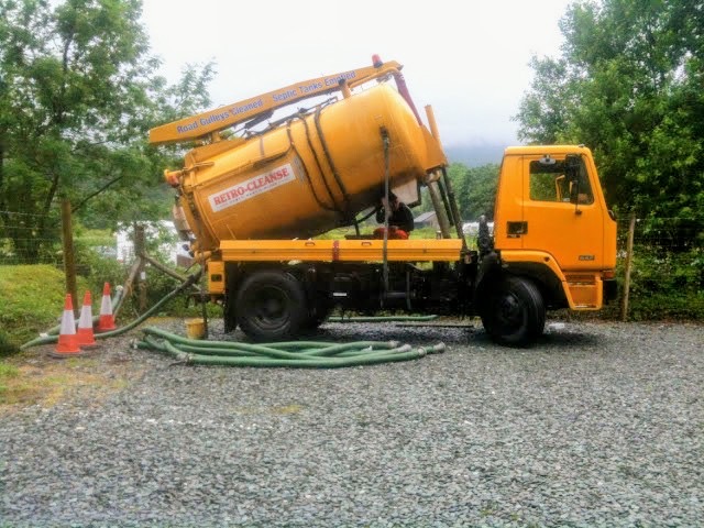 Retro-Cleanse yellow tanker with hoses on a gravel site
