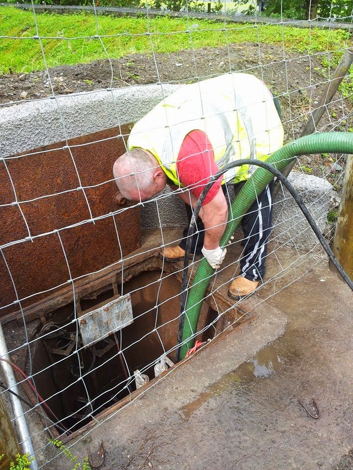 Retro-Cleanse engineer emptying a septic tank with a suction hose