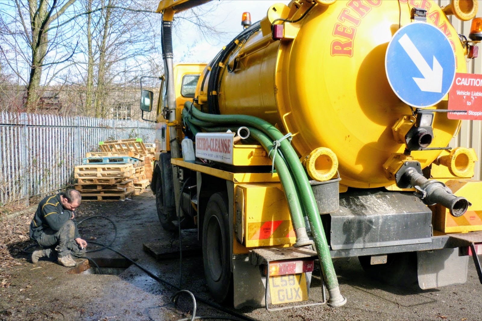 Retro-Cleanse tanker with suction hoses at a drain